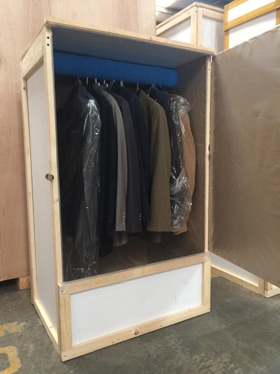 Clothes hanging inside an opened Four Winds Saudi Arabia wardrobe crate