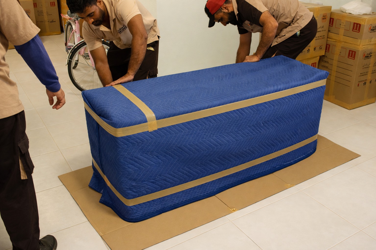 Four Winds Saudi Arabia movers protecting furniture with a moving blanket